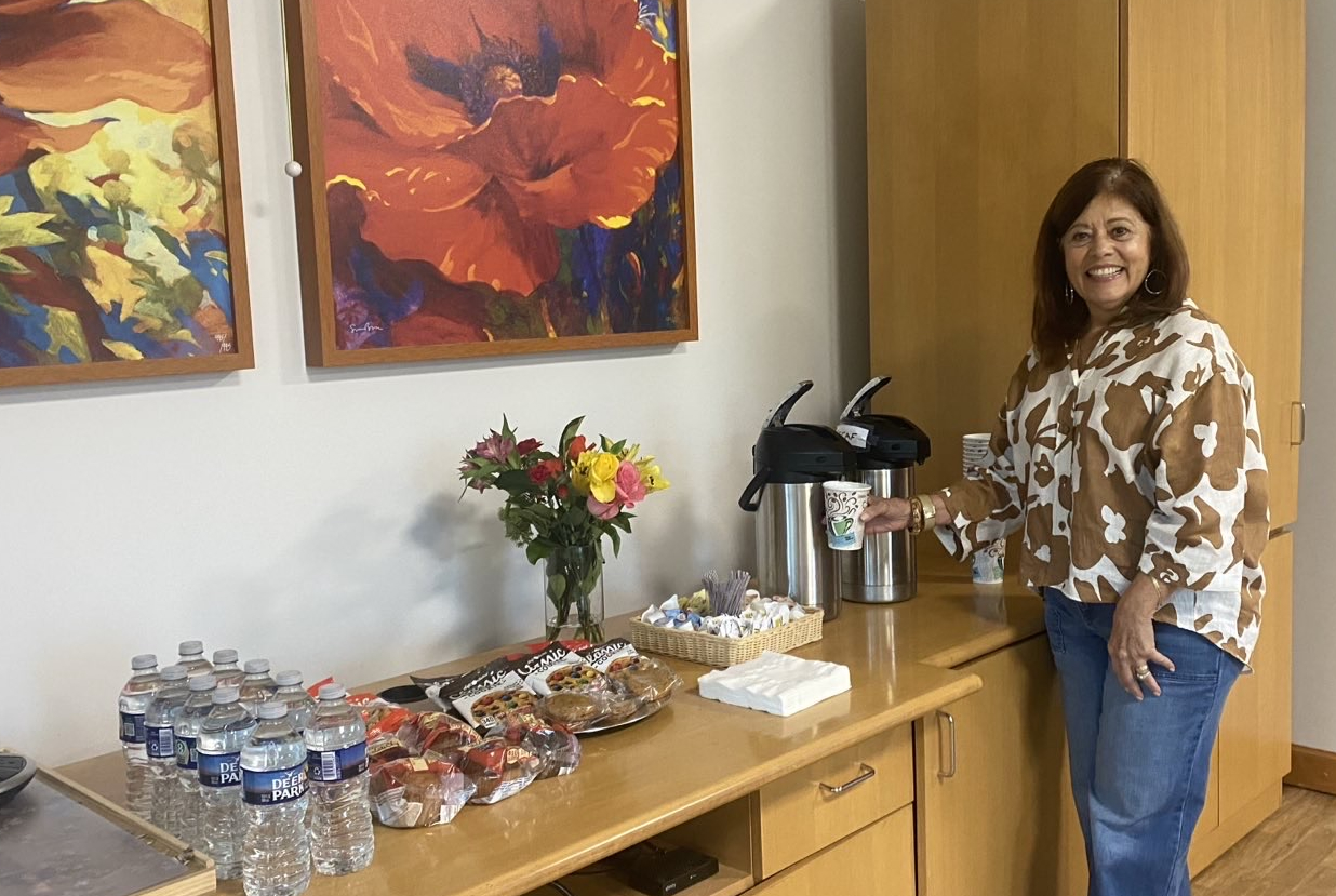 A seminar guest pours herself a coffee from the refreshments table